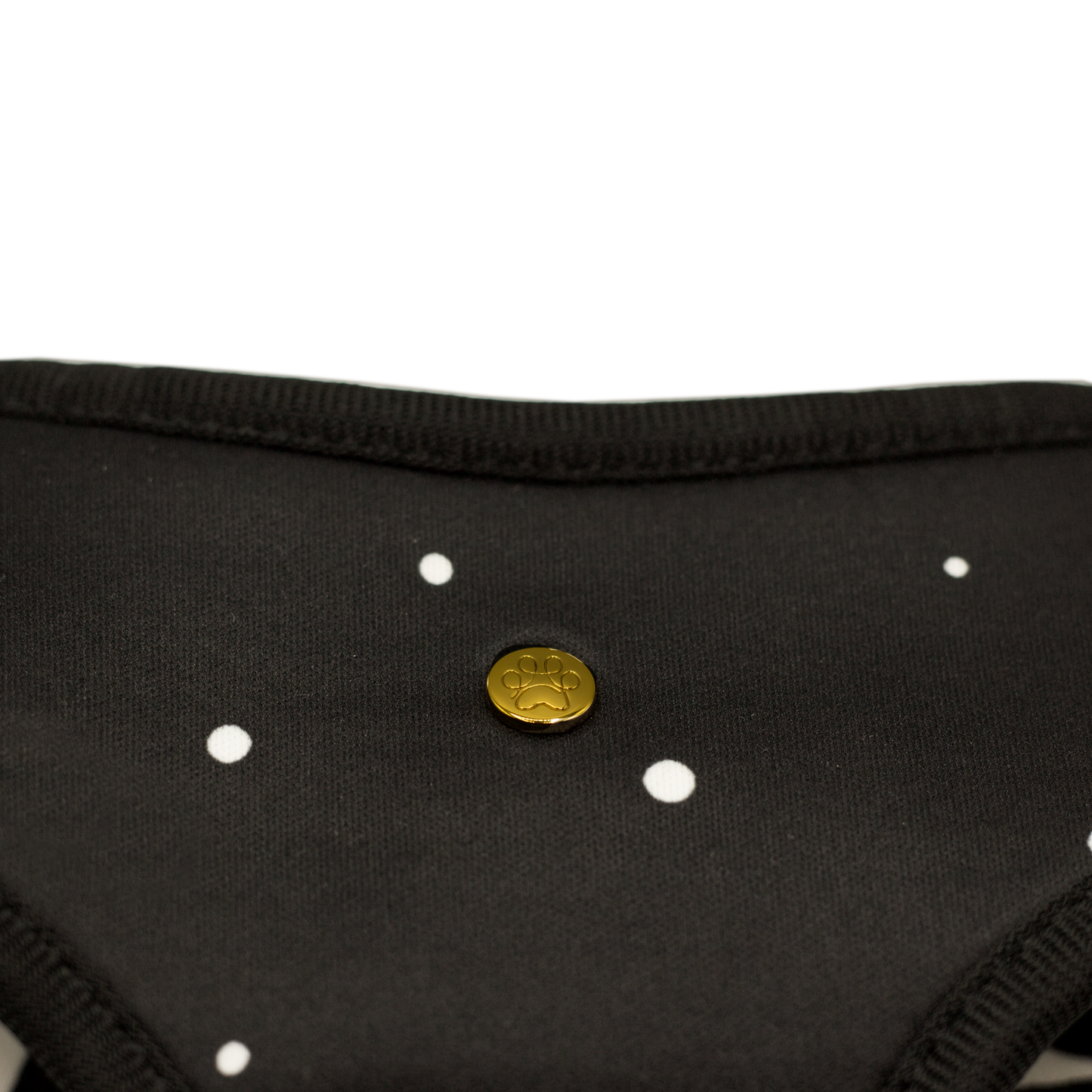 Pata Paw moo reversible harness showing a close-up of its golden paw and a timeless and chic design of hand-painted dots on a black background.