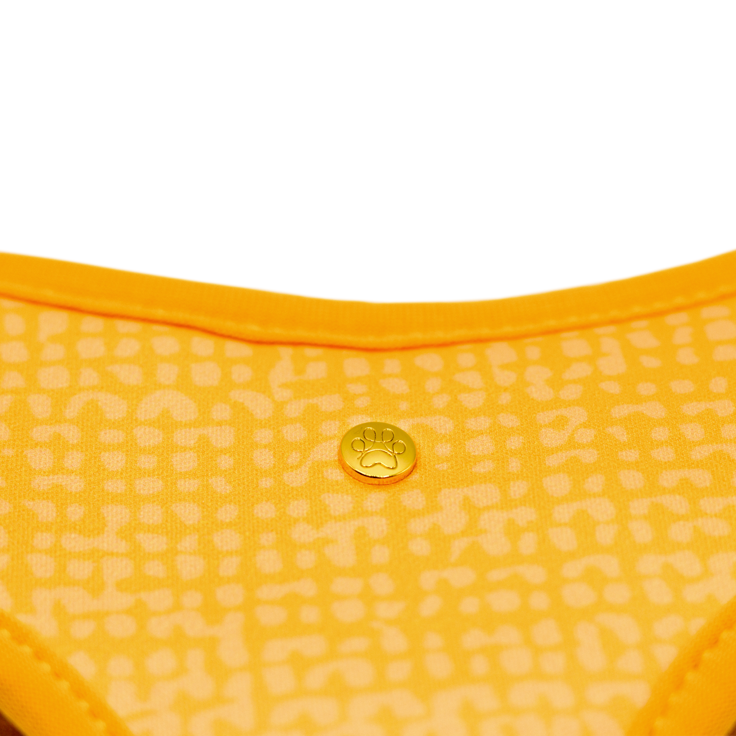 Pata Paw traveling pups  reversible harness showing a close-up of its golden paw and a timeless and chic texture pattern in dijon yellow.